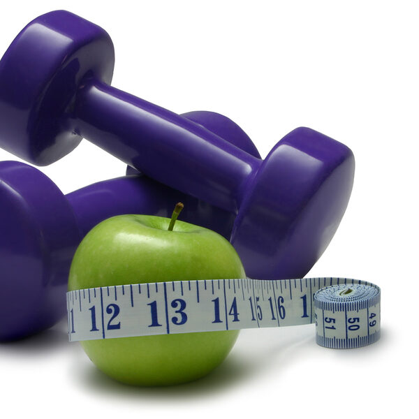 Dumbells green apple and tape measure isolated on white.